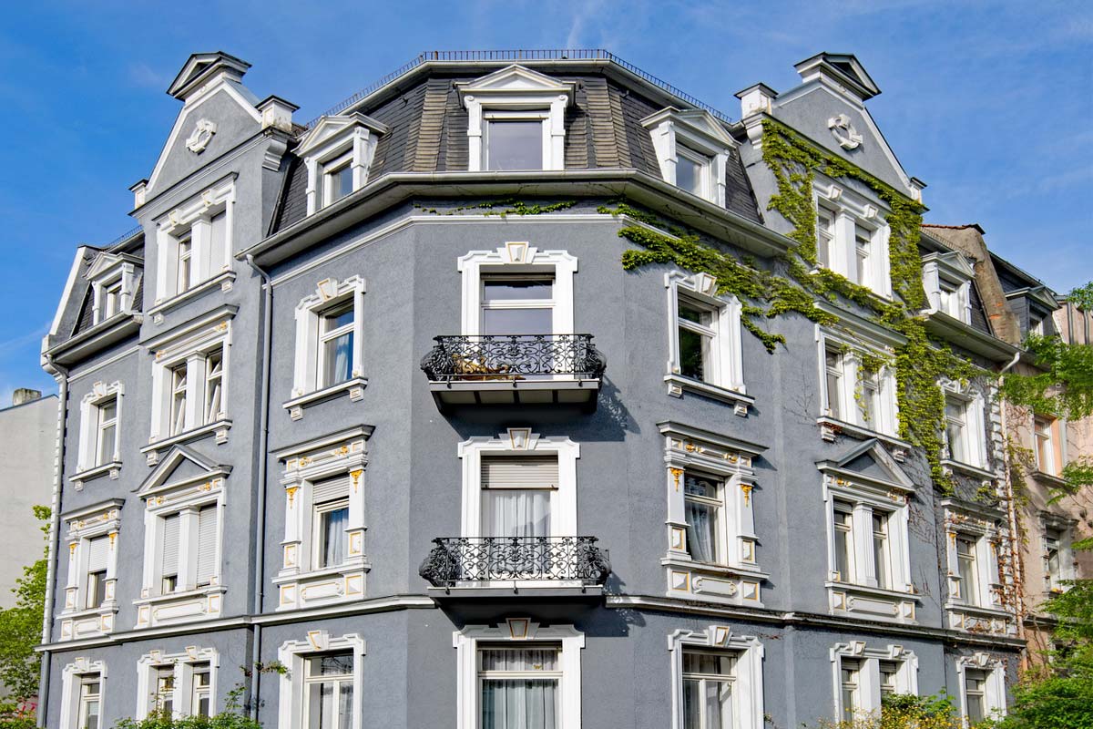 Bestandsimmobilie mit blauer Fassade und weißen Fenstern